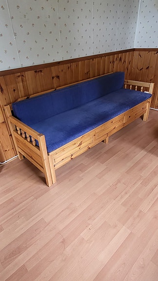 Tukeva ulosvedettävä puinen sohvasänky.