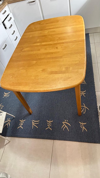 Tyylikäs jatkettava puinen ruokapöytä.