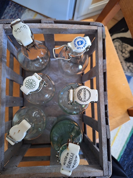 6 kpl erilaisia patenttikorkkipulloja puisessa laatikossa