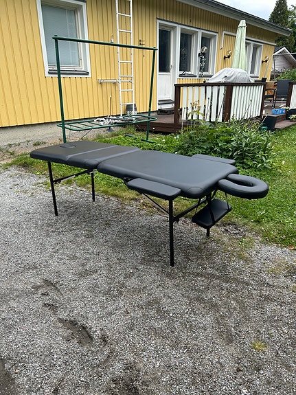 Musta taitettava hierontapöytä