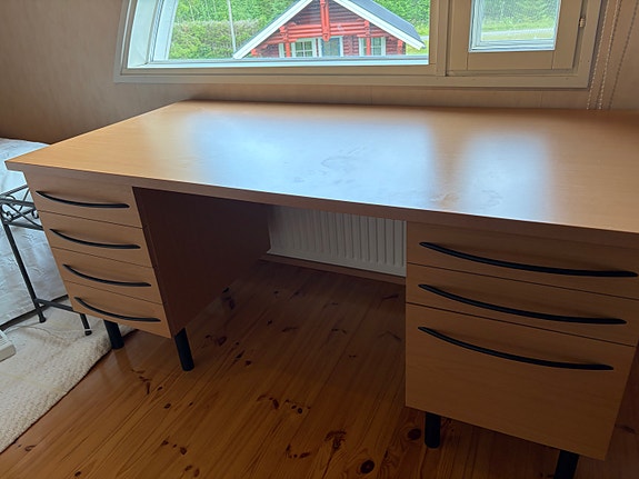 Vaalea kirjoituspöytä laatikostoilla