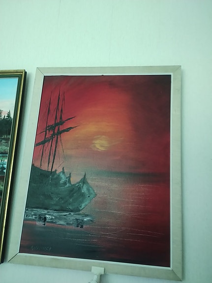 Meriaiheinen taulu punaisella auringonlaskulla