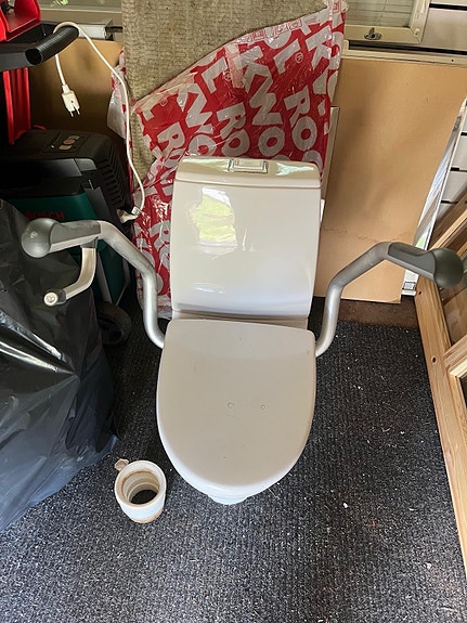 Valkoinen wc-istuin tukikahvoilla