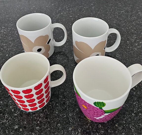 4 mukia: Marimekon Unikko, Iittalan Primavera sekä Arabian Omena -mukit