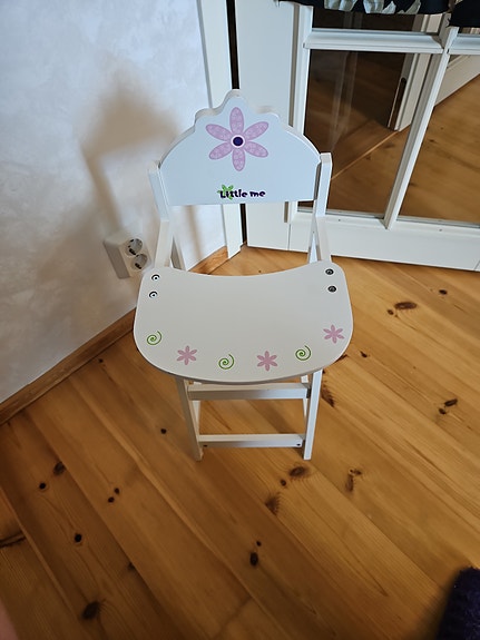 Valkoinen nuken syöttötuoli.