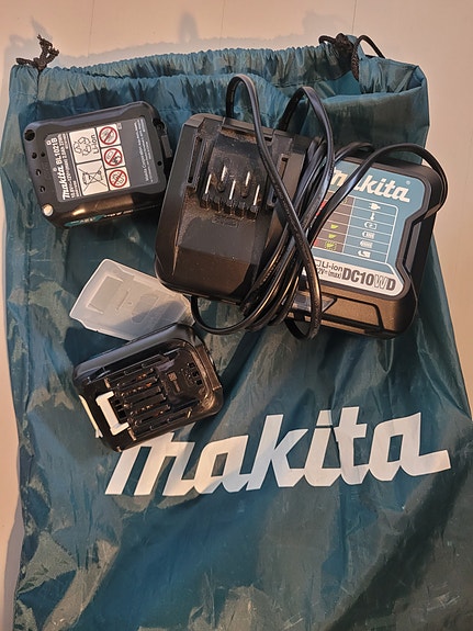 Makitan trimmerin akkulaturi sekä kaksi akkua