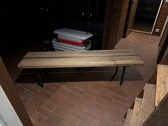 Puinen pitkä penkki metallijaloilla