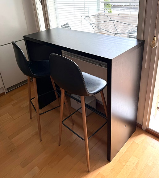 Musta baaripöytä ja kaksi tuolia