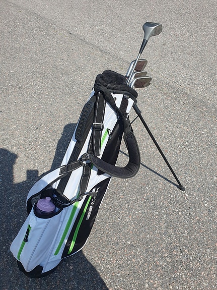 Naisten/nuorten golfbägi ja mailasetti jalustalla