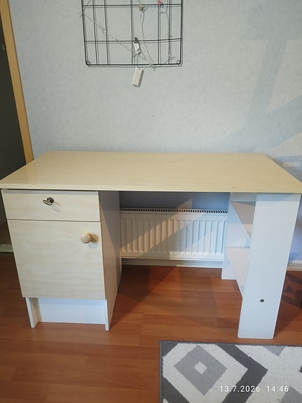 Vaalea kirjoituspöytä laatikolla ja kaapilla