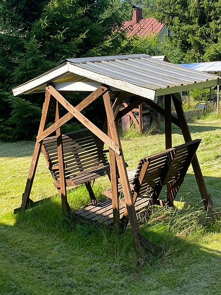 Puinen pihakeinu katoksella