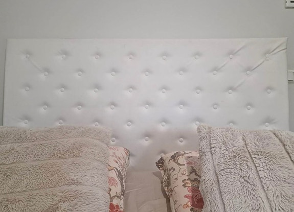 Valkoinen sängynpääty nappikoristeilla