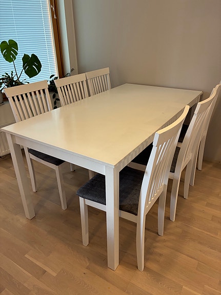 Valkoinen ruokapöytä ja kuusi tuolia