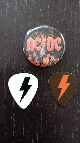 AC/DC plektrat ja rintanappi