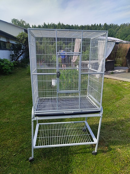 Iso harmaa lintuhäkki pyörillä