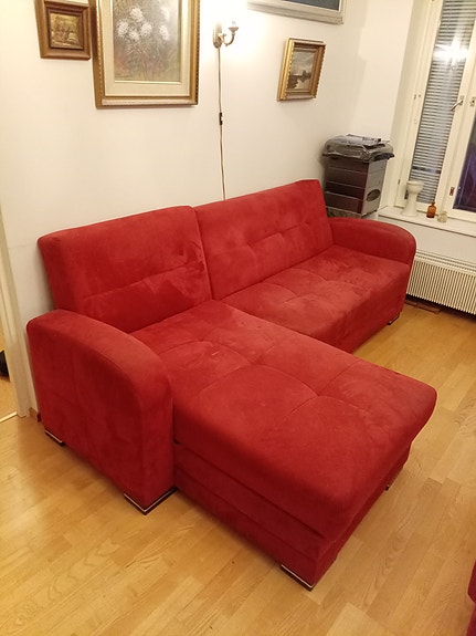 Punainen kulmavuodesohva rahilla