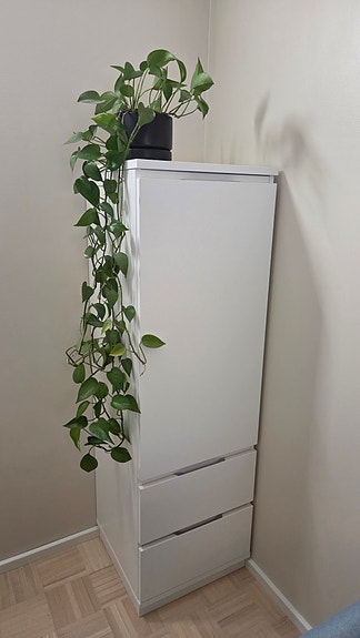 Valkoinen kaappi hyllyillä ja laatikoilla