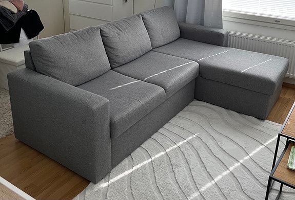 Vaaleanharmaa vuodesohva divaanilla