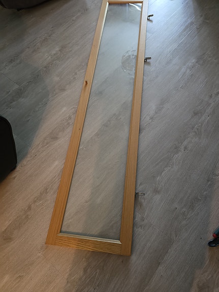 Lasinen kaapin ovi puureunuksella