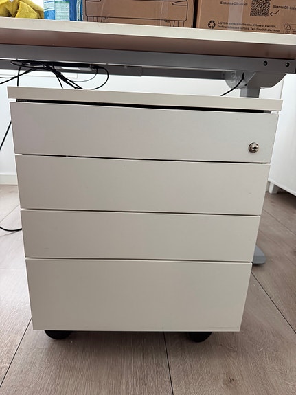 Iskun valkoinen laatikosto pyörillä