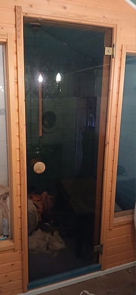 Saunan lasiovi puukarmeilla
