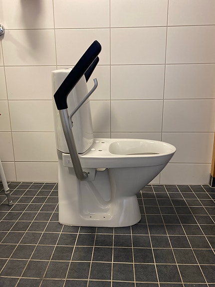 Valkoinen wc-istuin (IDO seven D 11) tukikaiteilla
