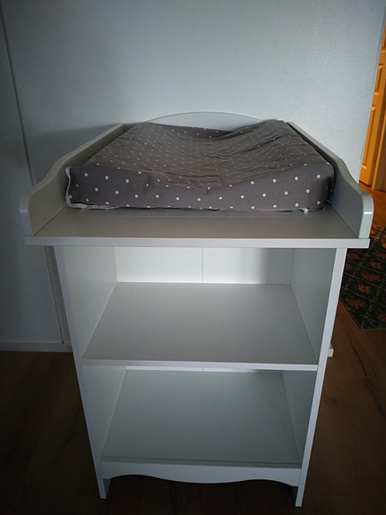 Valkoinen hoitopöytä hyllyillä