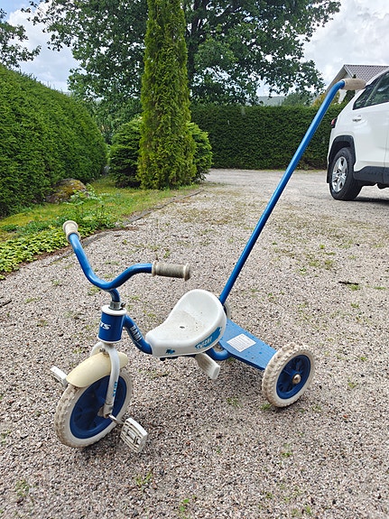 Lasten kolmipyörä työntöaisalla