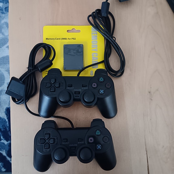 Playstation 2 ohjaimet, sekä muistikortti.