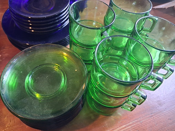 Vihreät lasiset kahvikupit ja aluslautaset
