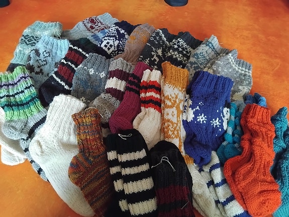Käsinkudotut villasukat eri väreissä ja kuvioissa
