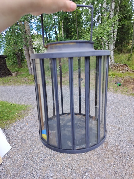 Musta metallinen lyhty lasipaneeleilla
