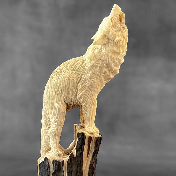 Kaiverrus, A howling wolf carving from deer antler on a custom stand - 17 cm -